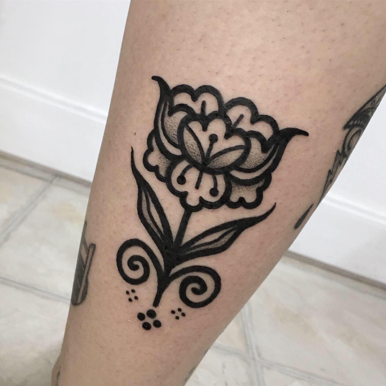 Tatuaje de flor con líneas finas realizado en Amatista Tattoo Studio